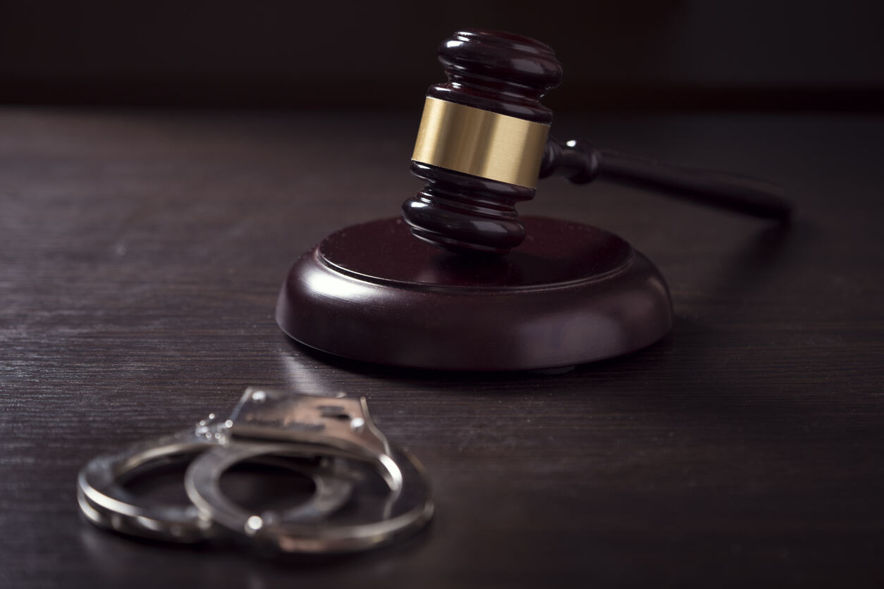 Criminal Defense Lawyer Alpharetta Gavel on the top of table and hancuffes , representing Criminal Defense Lawyer in Alpharetta.