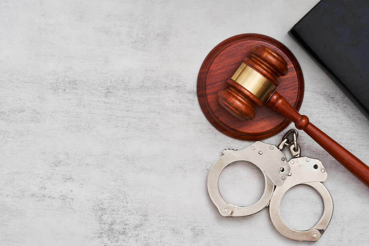 Lawyer Gavel and Hand cuffs on the table representing Criminal Defense Lawyer Marietta