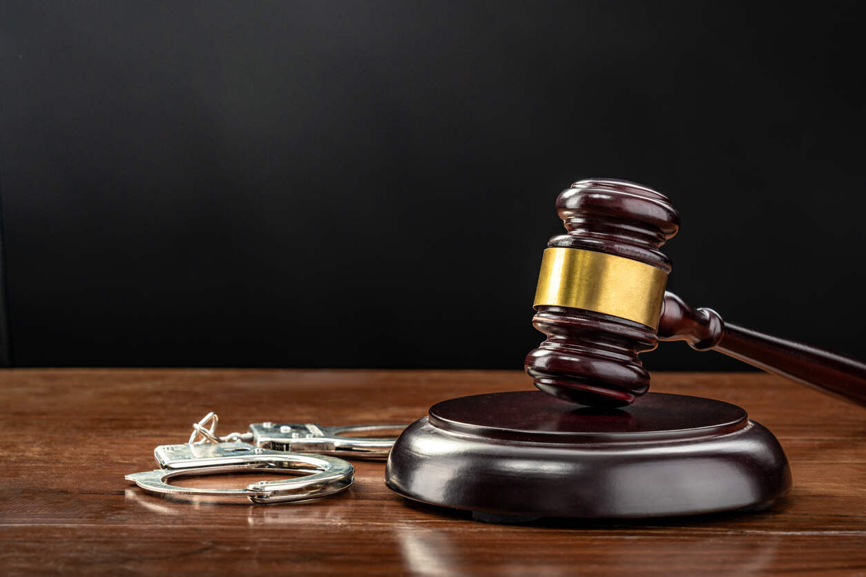Criminal Defense Lawyer Roswell Lawyer handcuffs and gavel on the table representing Criminal Defense Lawyer Roswell.