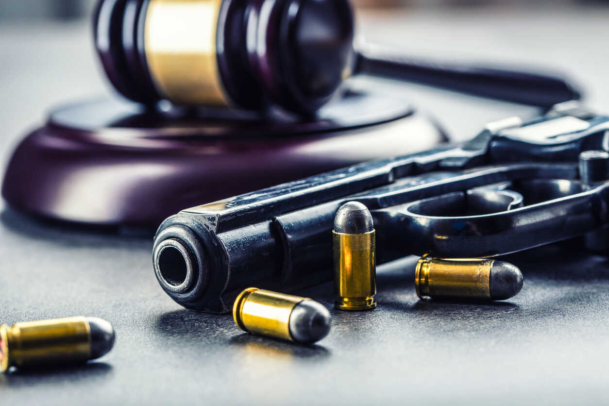 Gun Crimes Lawyer ose-up of a gavel, handgun, and bullets, representing gun crime cases and legal defense in Cobb County.